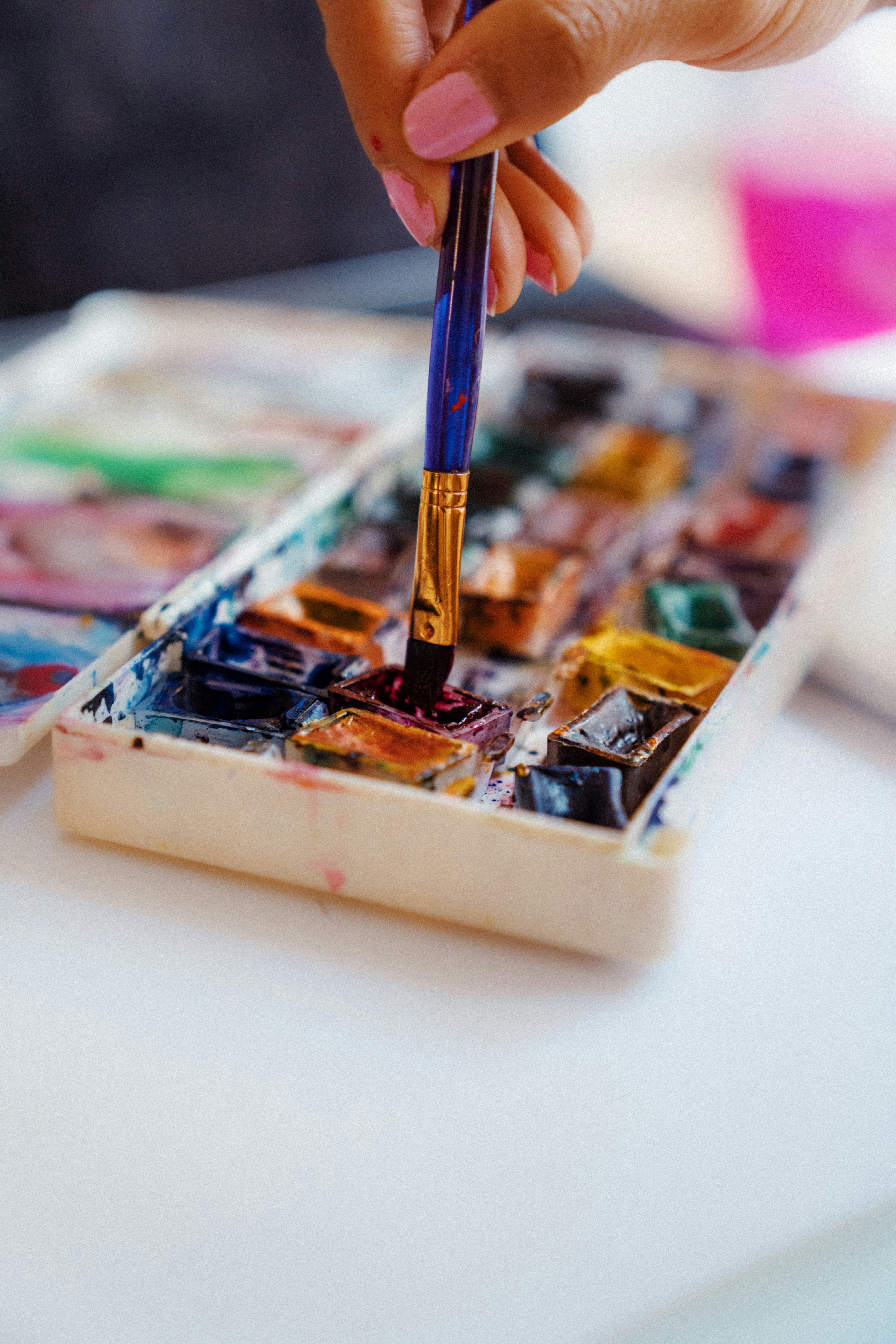 person holding blue pen on white and brown wooden box